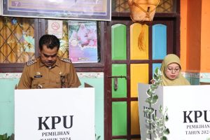 Pj.Bupati Pinrang Bersama Pj.Ketua Tim Penggerak PKK Pinrang Manyalurkan Hak Suaranya di TPS 01